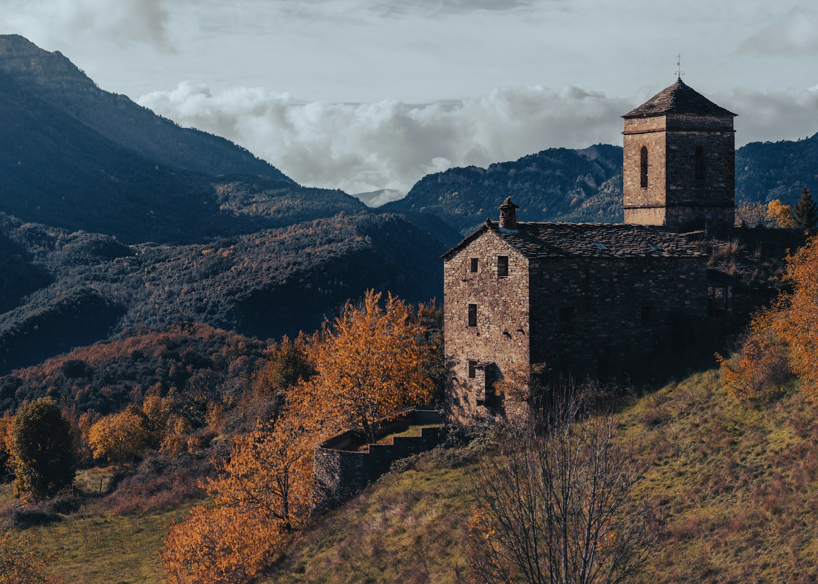 An old building sitting on top of a lush green hillside