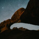Rock arch under a starry night sky